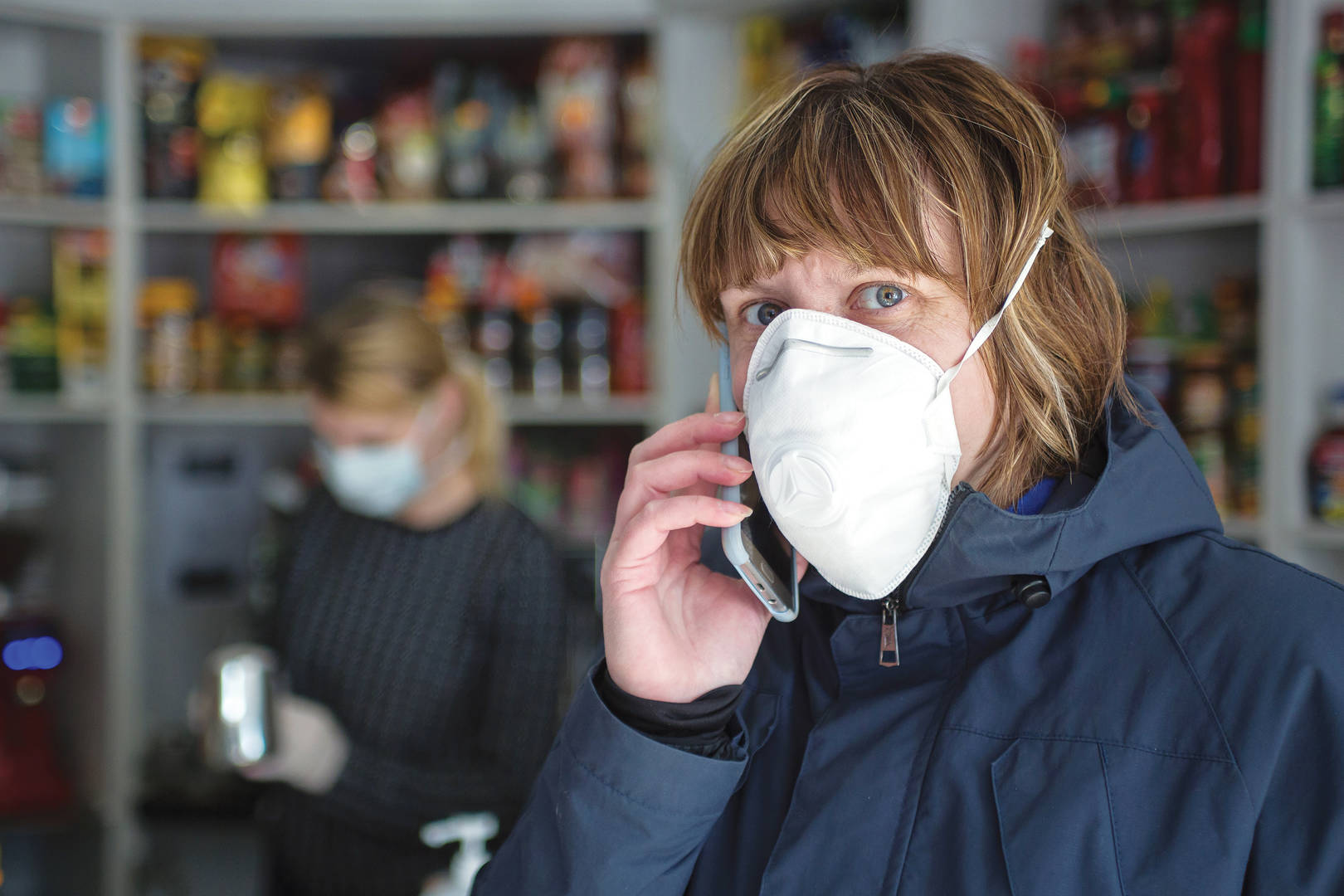 Store employee wearing a protective facemask while on the phone